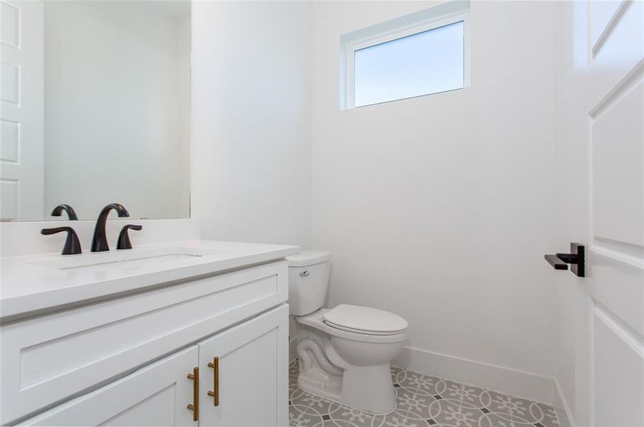 Bathroom with tile patterned floors, toilet, and vanity