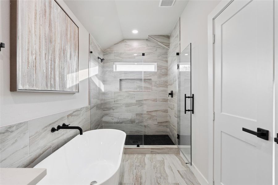 The bathroom’s spacious layout and oversized glass shower create a clean, modern retreat that feels fresh and upscale. Thoughtful finishes and a bright, open feel make this space as beautiful as it is practical.