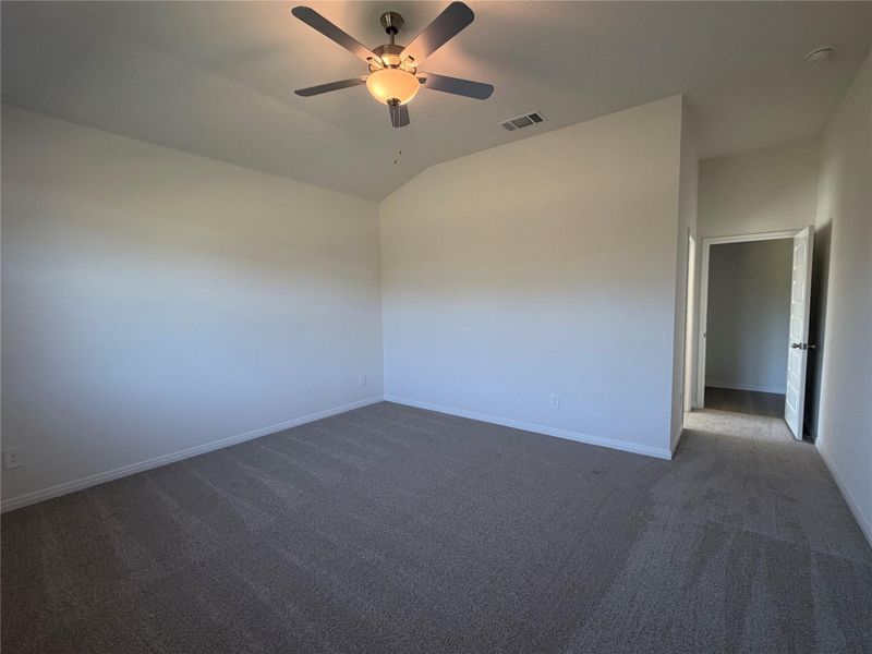 Unfurnished room with carpet, vaulted ceiling, and a ceiling fan