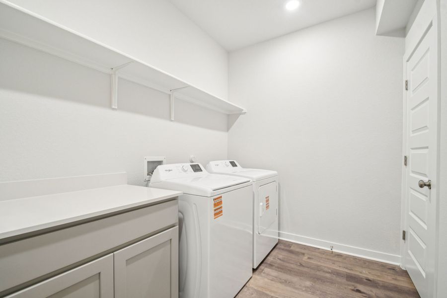 A room with white cabinets and a washing machine.