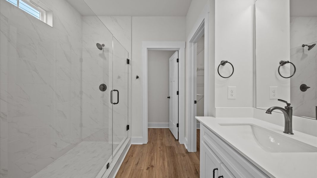 Superior en-suite primary bathroom with stylish dual vanity and walk-in shower crafted with high standards in mind Superior en-suite primary bathroom with stylish dual vanity and walk-in shower crafted with high standards in mind
