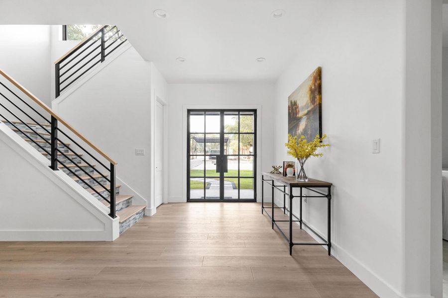 Doorway featuring plenty of natural light, stairway, recessed lighting, and wood finished floors
