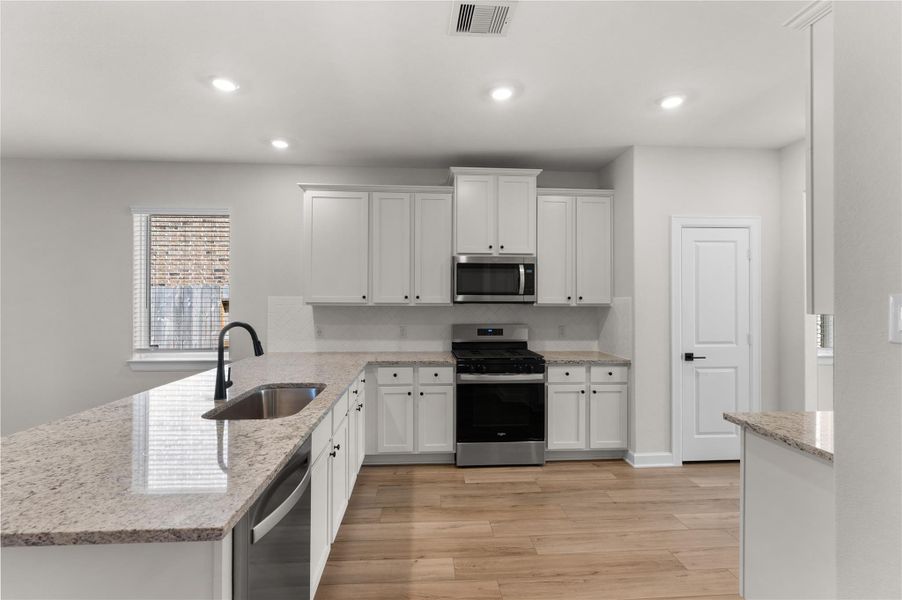Modern kitchen featuring granite countertops, stainless steel appliances, a large breakfast bar, and abundant cabinet space. Open to the living area, making it perfect for entertaining and everyday living Modern kitchen featuring granite countertops, stainless steel appliances, a large breakfast bar, and abundant cabinet space. Open to the living area, making it perfect for entertaining and everyday living