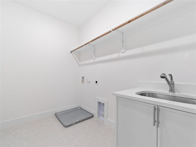 Laundry area featuring electric dryer hookup, cabinet space, washer hookup, and light tile patterned floors