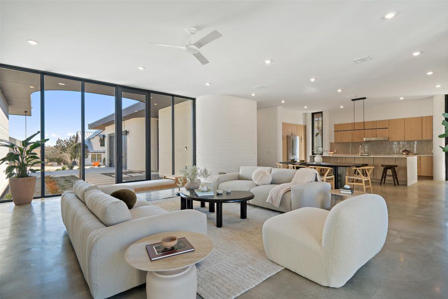 Living room with ceiling fan and floor to ceiling windows