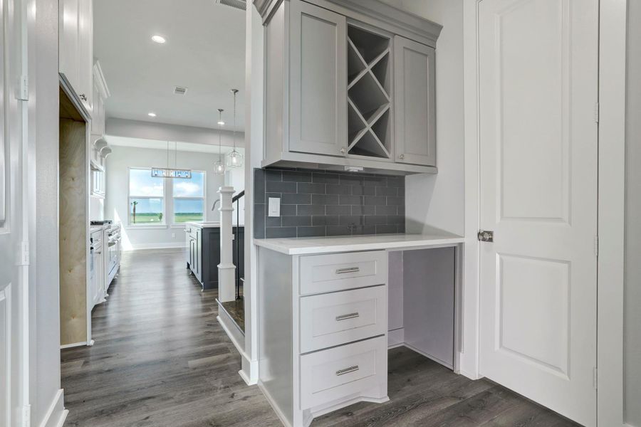 Butlers station with drawers, cabinets, built in wine rack & room for a beverage fridge. A half bath is located on the right. Butlers station with drawers, cabinets, built in wine rack & room for a beverage fridge. A half bath is located on the right.