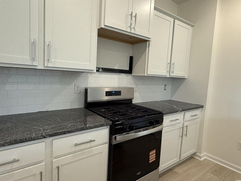 Kitchen view of tasteful backsplash and dark countertops Kitchen view of tasteful backsplash and dark countertops