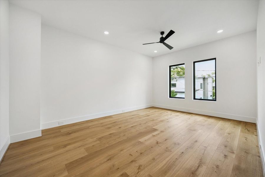 Spacious secondary bedroom with hardwood floors and oversized windows. Spacious secondary bedroom with hardwood floors and oversized windows.