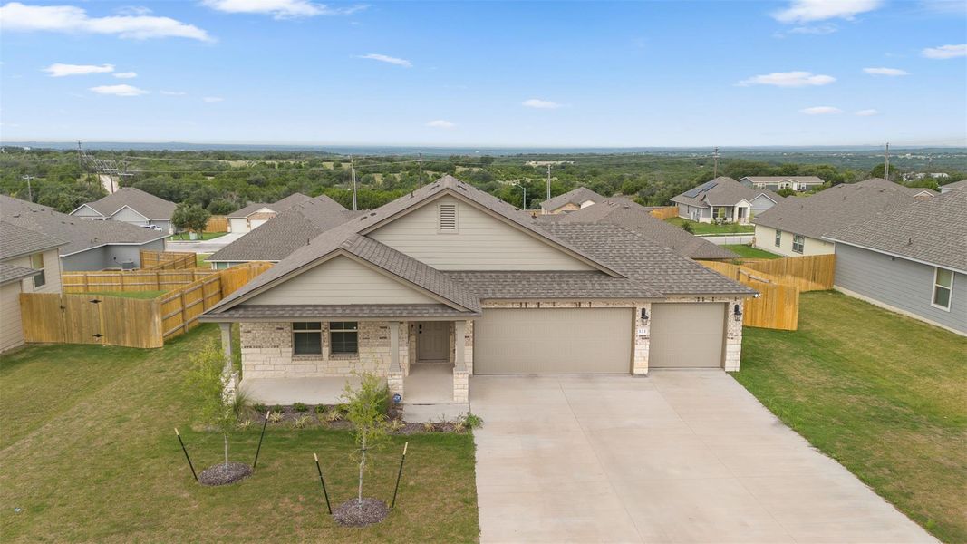 View of front of house featuring a residential view, a shingled roof, an attached garage, driveway, and brick siding