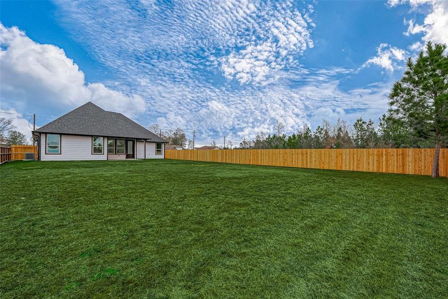 The spacious backyard offers endless possibilities for relaxation and enjoyment.  (Note: The grass has been digitally enhanced to show potential.)