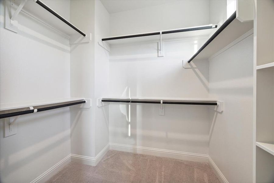 This walk-in closet in the primary bedroom provides abundant hanging space and shelving for organized storage, offering plenty of room to keep your wardrobe and accessories neatly arranged.