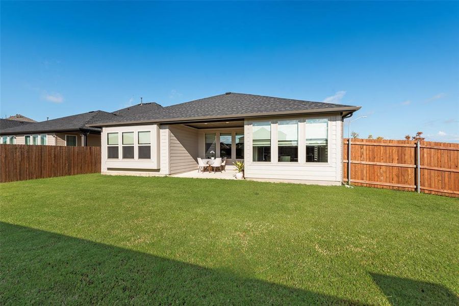 Back of house with a patio area, a fenced backyard, and roof with shingles