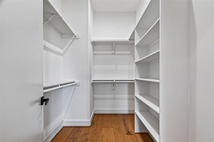 Primary bedroom closet featuring custom shelving. Primary bedroom closet featuring custom shelving.