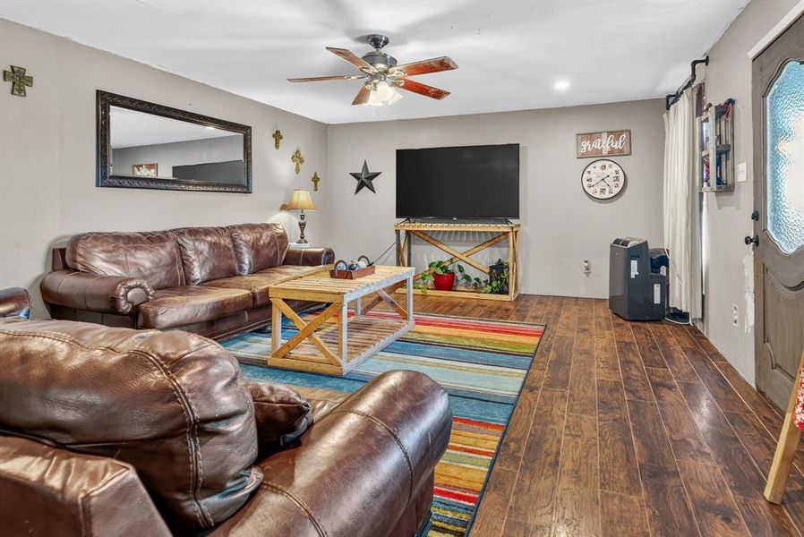 Living room featuring hardwood / wood-style floors and a ceiling fan Living room featuring hardwood / wood-style floors and a ceiling fan