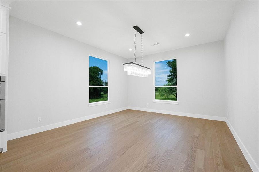 Unfurnished room featuring light wood-style flooring, recessed lighting, baseboards, and a chandelier Unfurnished room featuring light wood-style flooring, recessed lighting, baseboards, and a chandelier