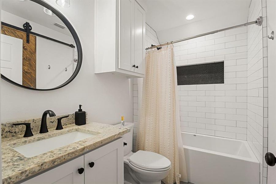 Bathroom with toilet, visible vents, recessed lighting, shower / bathtub combination with curtain, and vanity Bathroom with toilet, visible vents, recessed lighting, shower / bathtub combination with curtain, and vanity