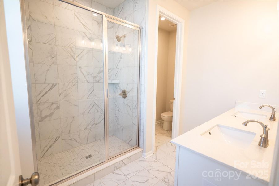 En Suite bath with dual vanity and modern walk-in shower.
