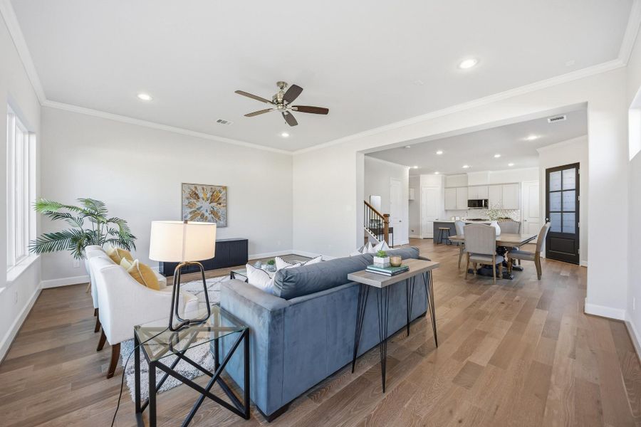 Effortless Flow: The spacious living room, with standard wood flooring, seamlessly connects to the dining area, creating a welcoming space designed for comfort and entertaining.