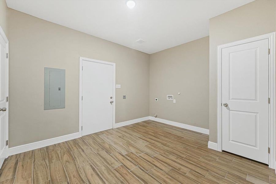 Spare room featuring electric panel and light wood-style floors Spare room featuring electric panel and light wood-style floors