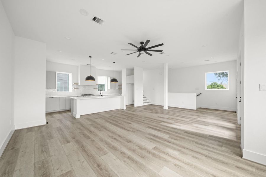 Accented by tall baseboards and large fixed windows, this living space creates a bright and airy atmosphere. Accented by tall baseboards and large fixed windows, this living space creates a bright and airy atmosphere.