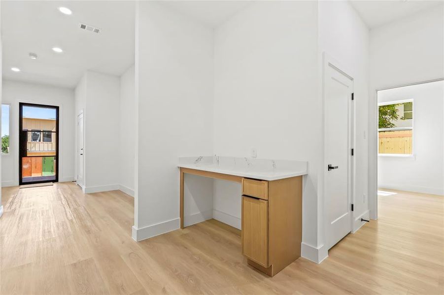 Hall with healthy amount of natural light, light wood-style floors, and recessed lighting
