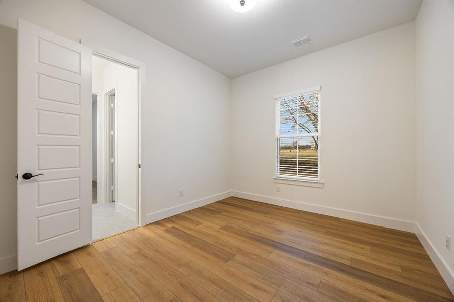 Empty room with light wood-type flooring and baseboards
