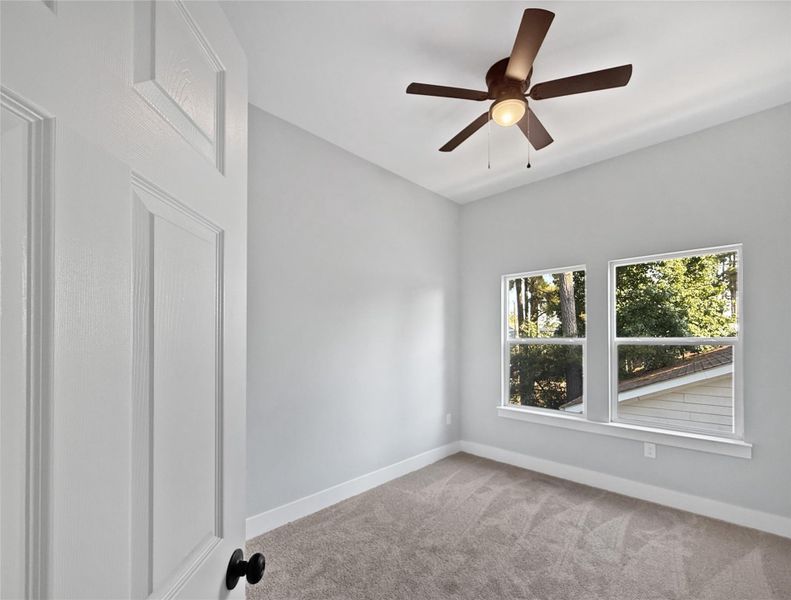 This spacious master suite is beautifully illuminated by abundant natural light through large windows.