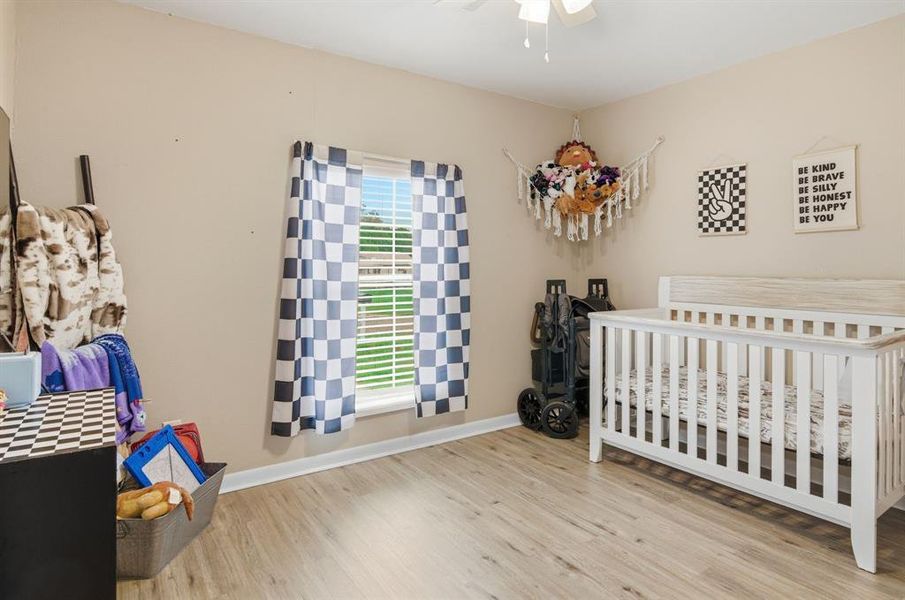Room featuring neutral wall paint, wood-finish flooring, and a window with blinds