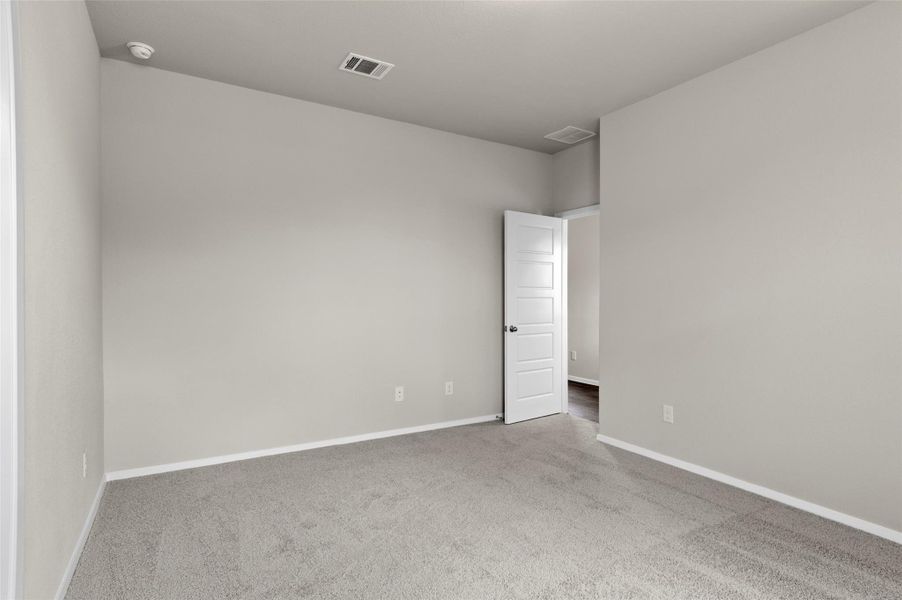 Carpeted spare room featuring baseboards