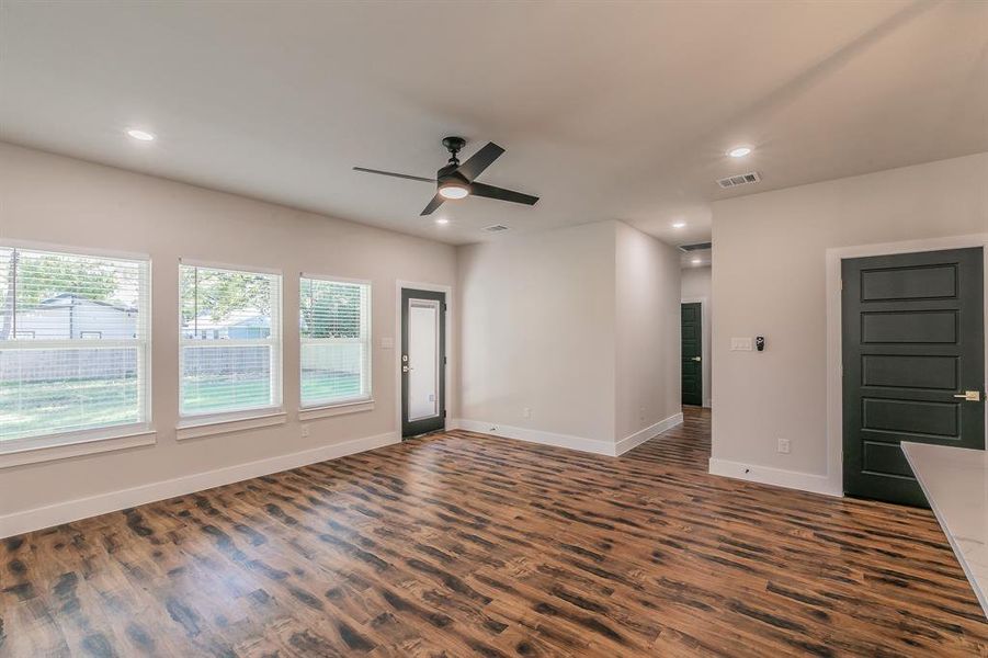 Unfurnished living room with ceiling fan and dark wood-type flooring