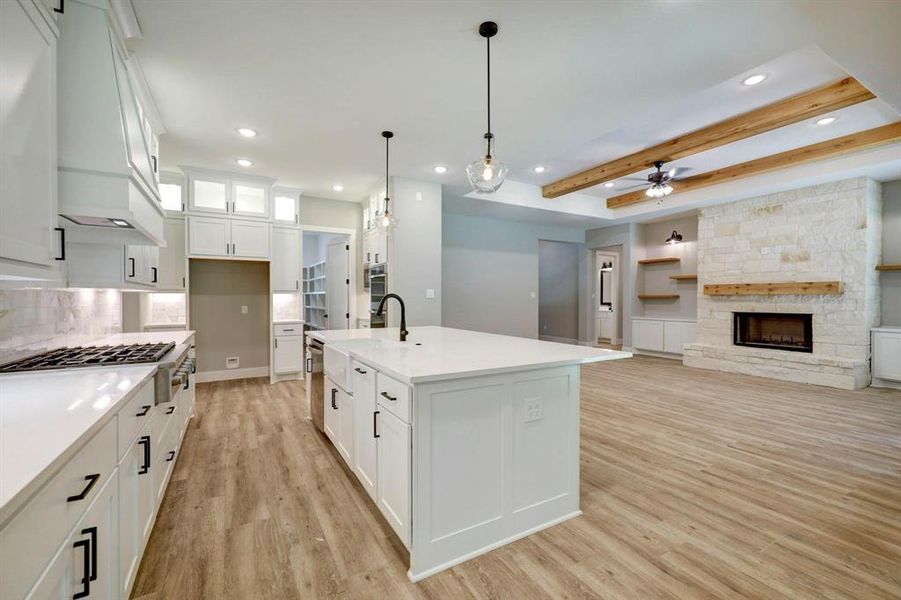 Crisp white cabinets with updated hardware provide a clean and timeless look, enhancing the sense of brightness and openness in the space.