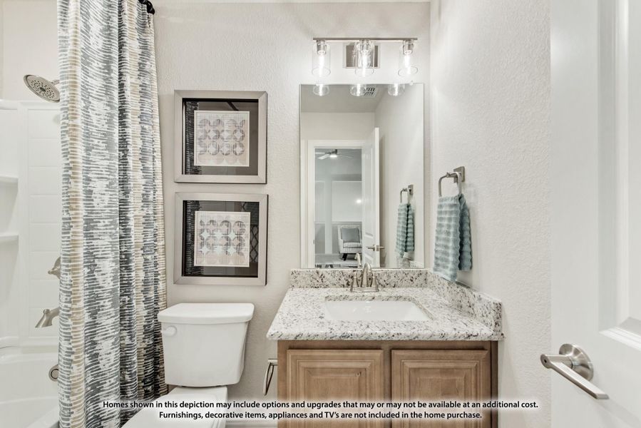 Bathroom with granite vanity, wood cabinets, large mirror, and shower with curtain Bathroom with granite vanity, wood cabinets, large mirror, and shower with curtain