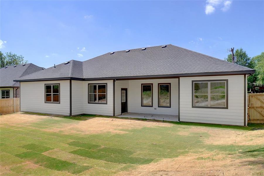Back of property with a shingled roof and a patio area Back of property with a shingled roof and a patio area