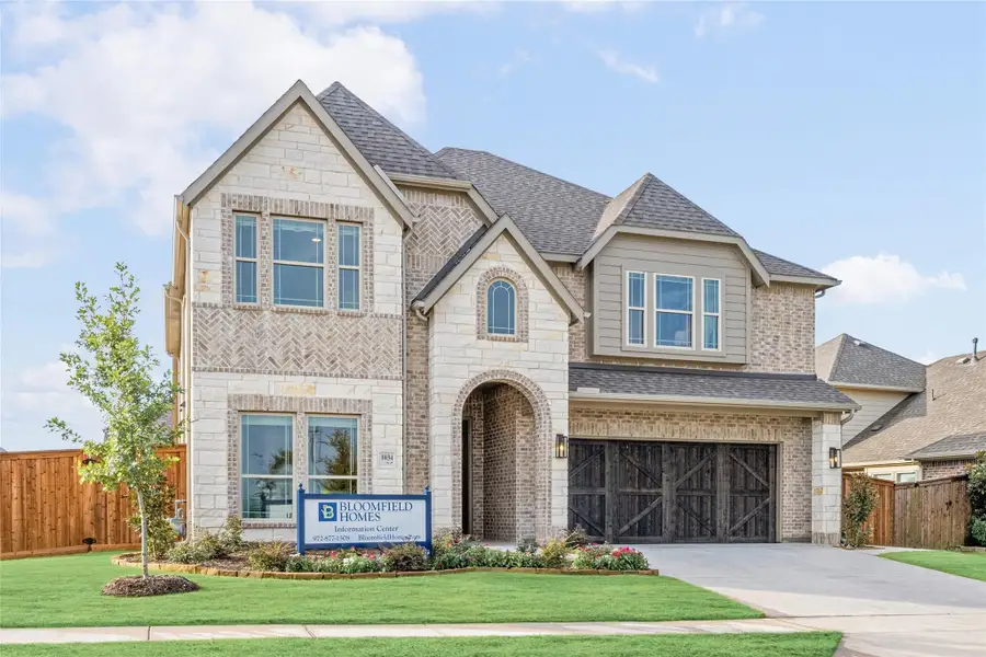 Two-story Bloomfield Homes model home with brick and stone exterior, arched entry, and two-car garage Two-story Bloomfield Homes model home with brick and stone exterior, arched entry, and two-car garage