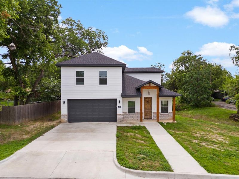 View of front of property with brick siding, a shingled roof, concrete driveway, and a garage View of front of property with brick siding, a shingled roof, concrete driveway, and a garage