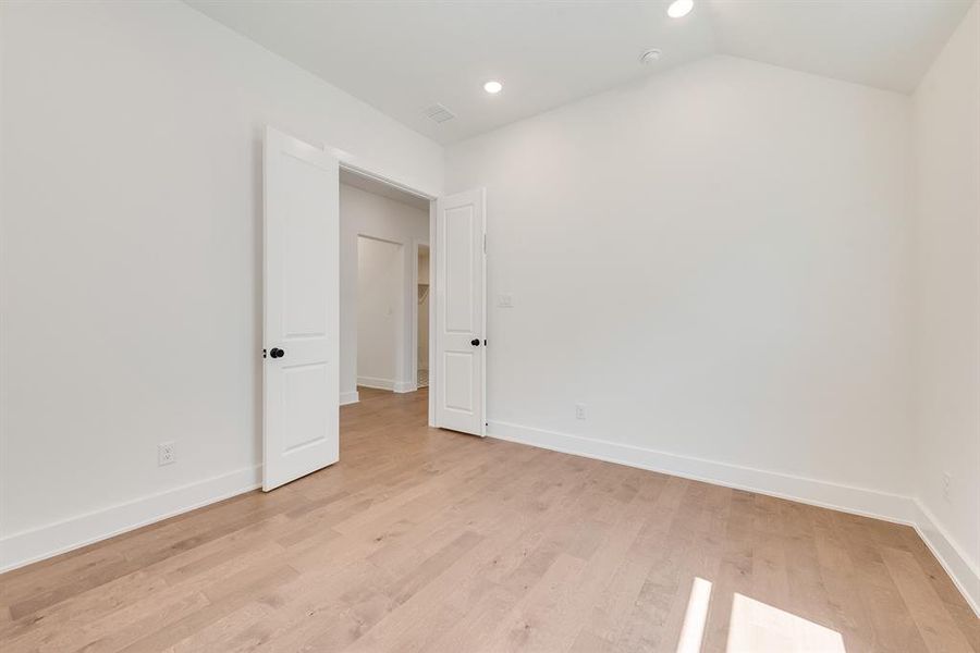 Spare room featuring light wood-type flooring, recessed lighting, and lofted ceiling Spare room featuring light wood-type flooring, recessed lighting, and lofted ceiling