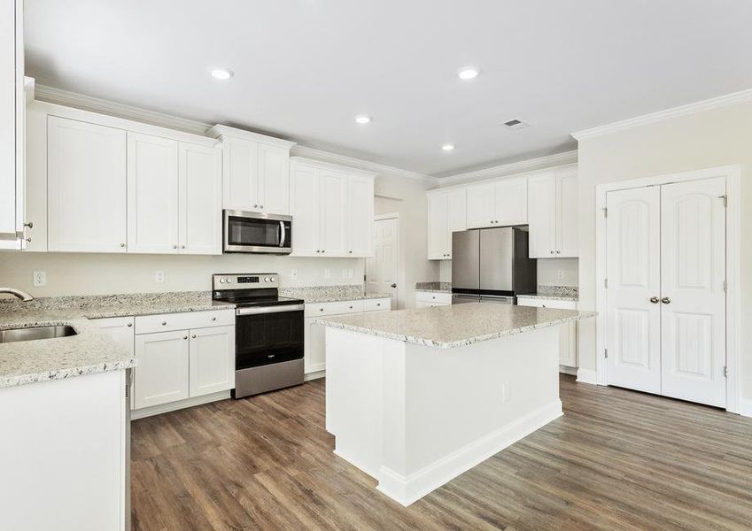 Kitchen with granite countertops, white cabinets and stainless steel appliances.