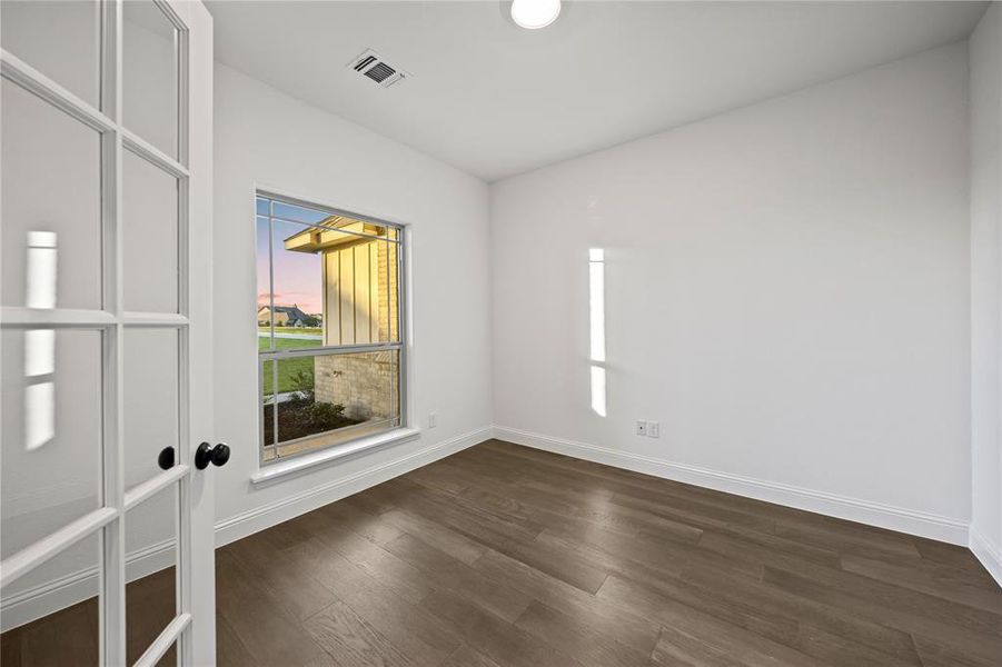 Empty room with dark wood finished floors and baseboards
