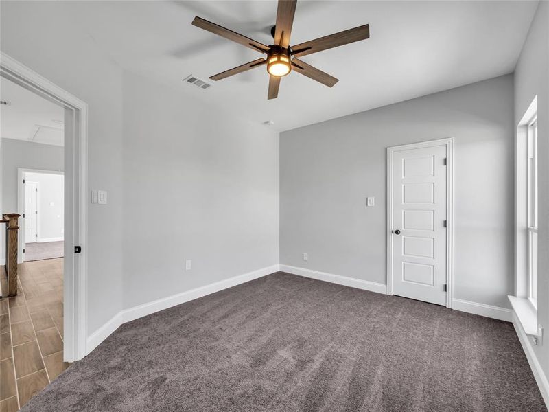 Carpeted upstairs bedroom with ceiling fan. Carpeted upstairs bedroom with ceiling fan.