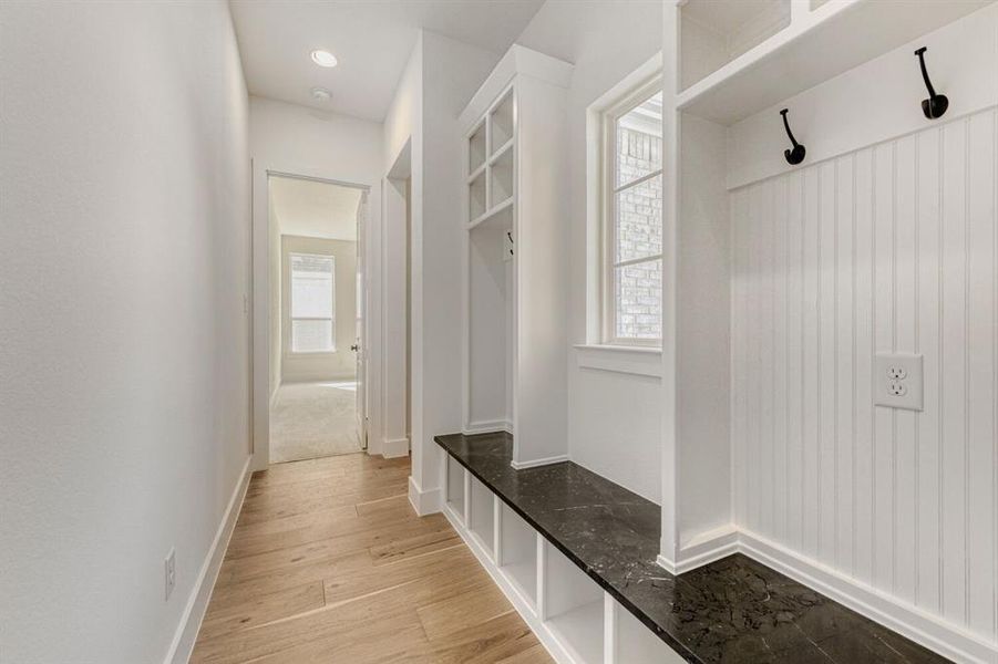 Mudroom with light wood-style floors and baseboards