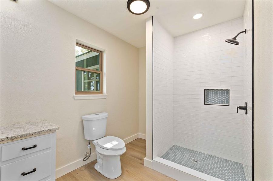 Bathroom with a stall shower, light wood finished floors, vanity, and recessed lighting Bathroom with a stall shower, light wood finished floors, vanity, and recessed lighting