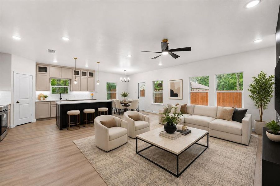 Open-concept living area featuring wood-finish flooring, recessed lighting, and a modern ceiling fan Open-concept living area featuring wood-finish flooring, recessed lighting, and a modern ceiling fan