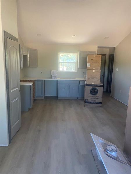 Kitchen featuring light countertops and dark wood-style flooring Kitchen featuring light countertops and dark wood-style flooring