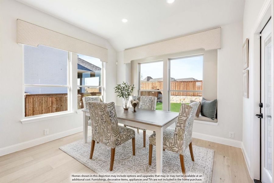 Bright dining area with white table, patterned chairs, window seat, and large windows overlooking backyard