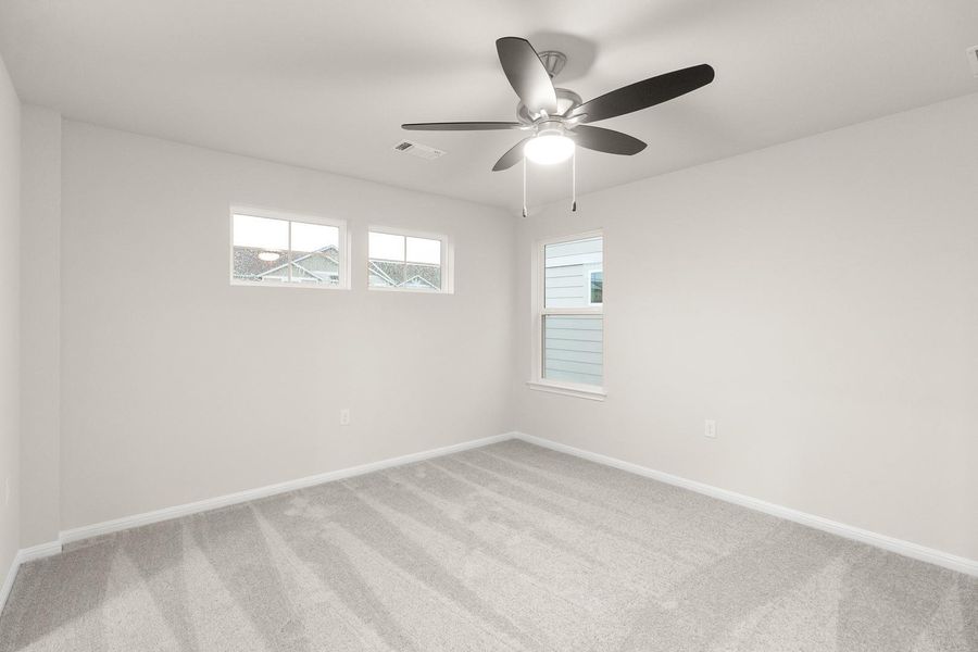 This room features light-colored walls, carpeted flooring, and a ceiling fan with integrated lighting