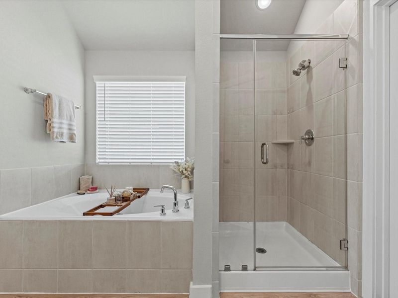 Walk-in shower and garden tub in the primary bathroom with tile surround.