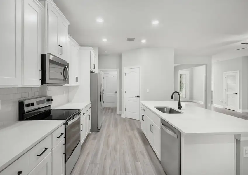 The kitchen includes stylish backsplash and granite countertops
