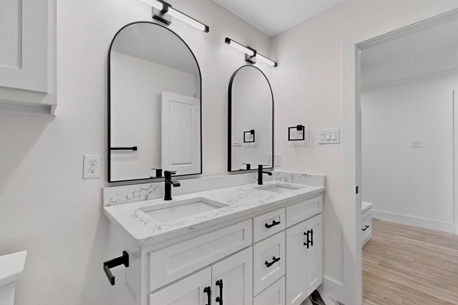 Bathroom featuring double vanity and light wood finished floors