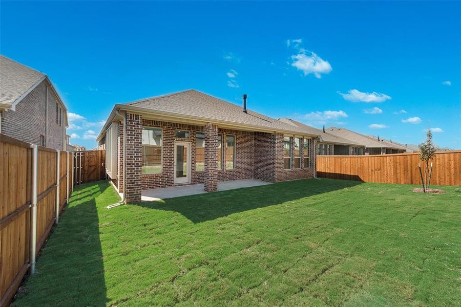 Rear view of property with a lawn and a patio