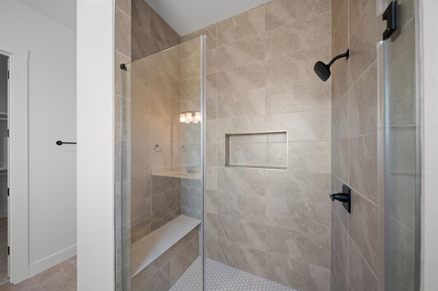 Full bath featuring a shower stall, tile patterned flooring, and a walk in closet